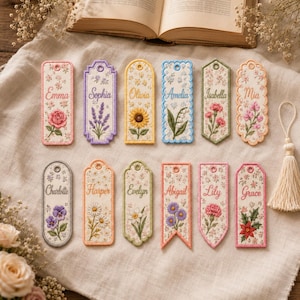 Puede incluir: Una colección de doce marcapáginas de tela rectangulares con diseños florales bordados y nombres como Emma, Sophia, Olivia, Amelia, Isabella, Mia, Charlotte, Harper, Evelyn, Abigail, Lily y Grace, cada uno con un pequeño agujero en la parte superior.