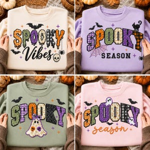 May include: A collection of four crewneck sweatshirts in cream, lavender, sage green, and light pink. Each features embroidered Halloween-themed graphics with text including Spooky Vibes and Spooky Season, decorated with bats, ghosts, skulls, and spiders.