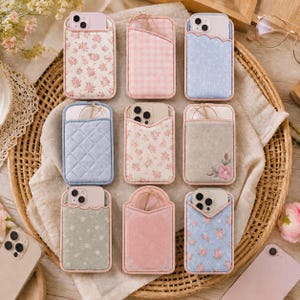 May include: Nine rectangular fabric phone card holders with various patterns including pink floral, pink gingham, blue floral, quilted blue, and solid pink. Each holder features a top pocket for cards and a cutout for a smartphone camera lens.