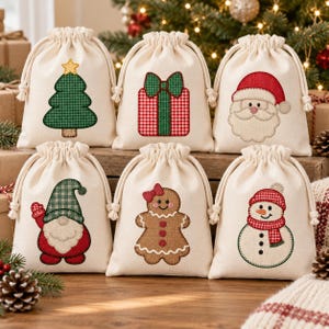 Puede incluir: Seis bolsas de regalo de color blanco roto con cordón y diseños navideños bordados, que incluyen un árbol de Navidad verde, un regalo rojo y verde, una cara de Papá Noel, un gnomo, un hombre de jengibre y un muñeco de nieve con bufanda.