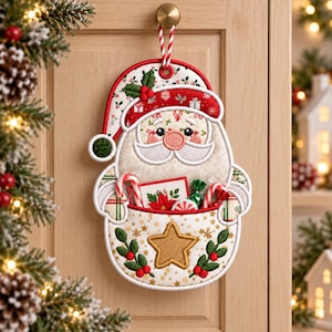 May include: A fabric Santa Claus wall hanging with a pocket containing candy canes and a small card. The Santa features a red hat with white trim, a gold embroidered star on the pocket, and green holly accents. It hangs from a red and white cord.