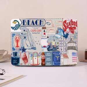 May include: A decorative laptop skin featuring a collage of nautical and beach-themed imagery. The design includes a sailboat, lighthouse, lobster, and the words "BEACH" and "SEAFOOD". The color palette is primarily blue, white, and red.