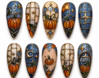 May include: A set of ten almond-shaped press-on nails featuring stained glass-inspired designs. The patterns include orange pumpkins, crescent moons, and gold star accents set against blue, cream, and beige backgrounds with gold metallic outlines.