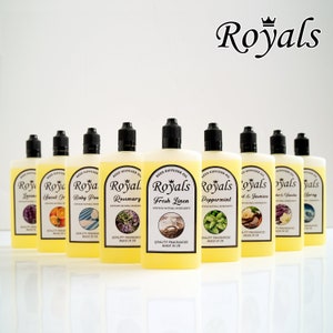 Può includere: Dieci bottiglie di vetro di olio per diffusore a bastoncini con vari profumi, tra cui lavanda, arancia dolce, talco per bambini, rosmarino, lino fresco, menta piperita, cuore e gelsomino, vaniglia e gelsomino, spray oceanico, e un logo a corona con la parola "Royals" sopra le bottiglie.