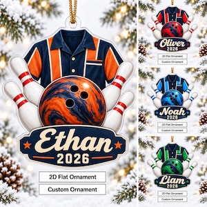 May include: A flat, custom-designed bowling ornament featuring a navy and orange bowling shirt, a marbled orange bowling ball, and white bowling pins with red stripes. A dark blue banner displays the name Ethan and the year 2026 in white text.