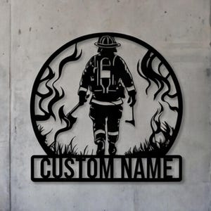 May include: A black metal wall sign featuring a circular frame with a silhouette of a firefighter walking away while holding an axe. The design includes stylized flames and a rectangular base at the bottom with the text CUSTOM NAME in capital letters.