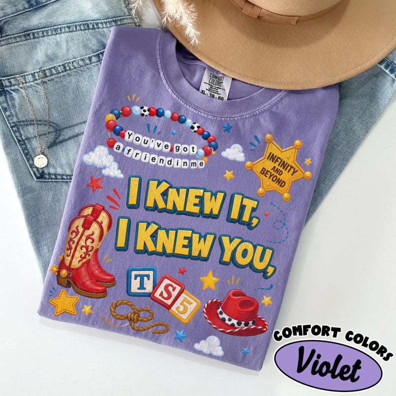 May include: A violet t-shirt featuring a graphic print with a beaded bracelet reading You've got a friend in me, a sheriff badge with Infinity and Beyond, red cowboy boots, a red cowboy hat, and blocks with TS5. The text reads I KNEW IT, I KNEW YOU.