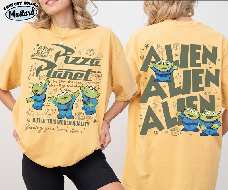 May include: Mustard-colored t-shirt featuring the Pizza Planet logo and three green aliens in blue suits. The front of the shirt has text that reads "Out of this world quality, serving your local star!" The back of the shirt has the word "ALIEN" repeated three times with alien graphics.