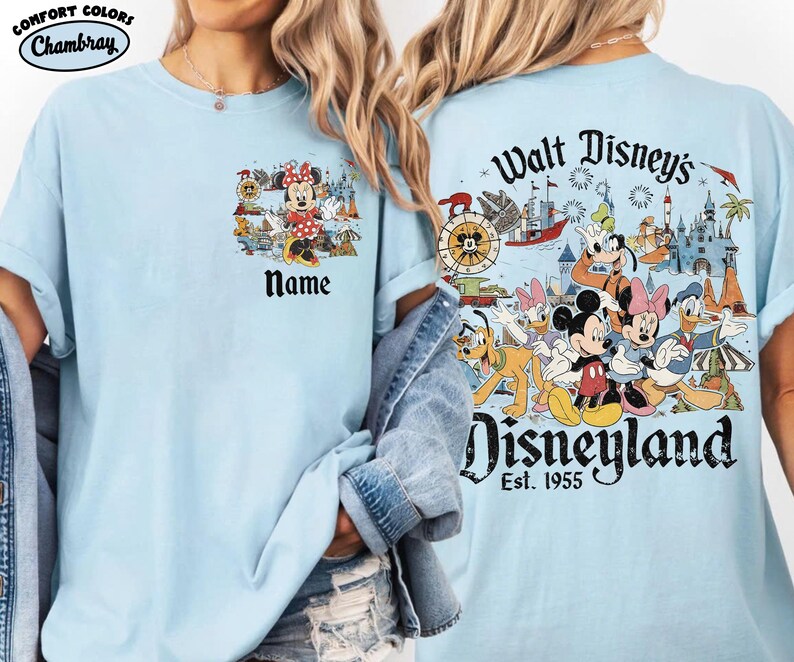 Peut inclure: T-shirt bleu clair avec Minnie Mouse et le mot "Name" sur le devant. Le dos du t-shirt pr&eacute;sente une illustration color&eacute;e de personnages Disney et le texte "Walt Disney's Disneyland Est. 1955".