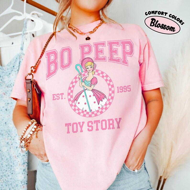 Pu&ograve; includere: Una tazza di ceramica bianca con manico nero e la scritta "But First, Coffee" in grassetto nero. La tazza &egrave; posta su uno sfondo sfocato, suggerendo un'atmosfera accogliente.