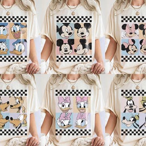 May include: Cream-colored t-shirts featuring cartoon character designs. Each shirt showcases a different group of characters in a grid pattern with a black and white checkered border. Characters include Donald Duck, Mickey Mouse, and Goofy.