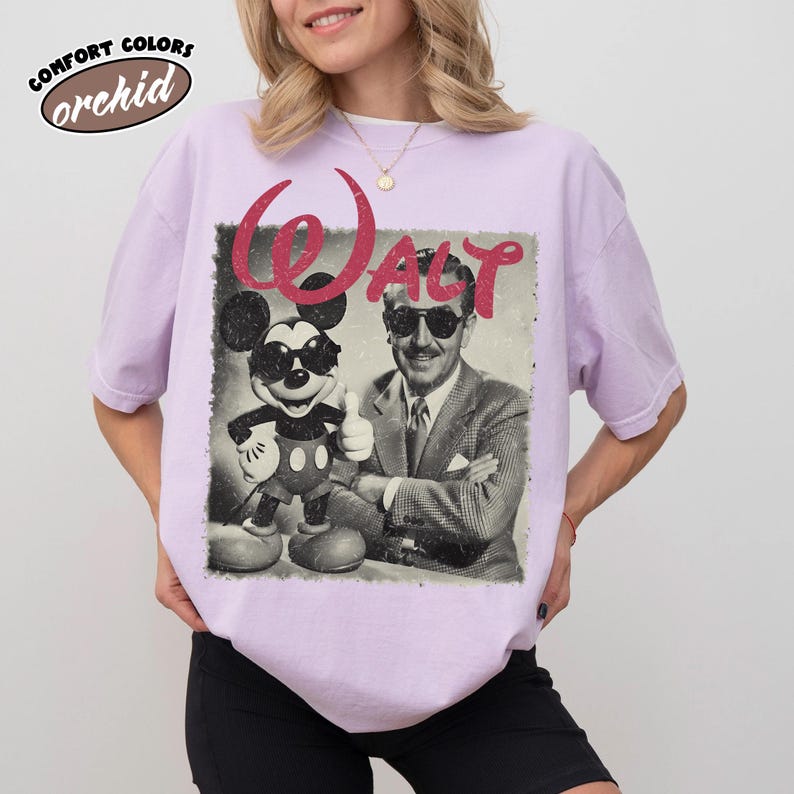 K&ouml;nnte beinhalten: Helllila Comfort Colors T-Shirt mit einem Vintage-Grafik von Mickey Mouse und Walt Disney mit Sonnenbrille. Das Wort "Walt" ist rot &uuml;ber dem Bild gedruckt. Das T-Shirt hat eine helle lila Farbe.