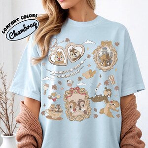 May include: Light blue t-shirt with a graphic featuring Chip and Dale in various frames and scenes. The shirt has the text "DOONEU WITH MY BESTIE" and "COMFORT COLORS Chambray" in a circular design.