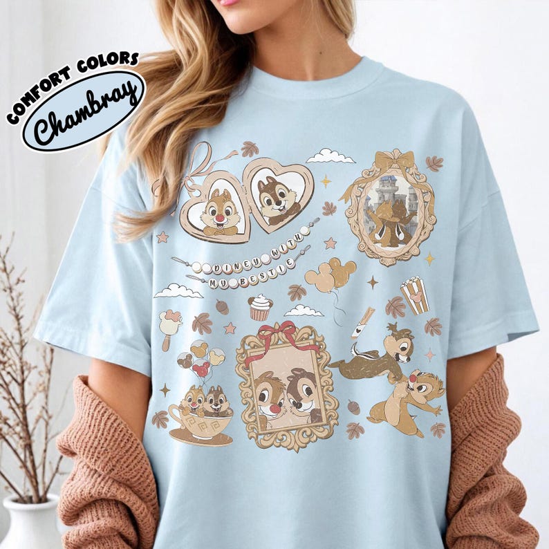 May include: Light blue t-shirt with a graphic featuring Chip and Dale in various frames and scenes. The shirt has the text "DOONEU WITH MY BESTIE" and "COMFORT COLORS Chambray" in a circular design.