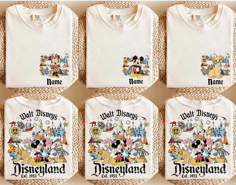 Peut inclure: Six t-shirts blancs avec des graphiques de personnages Disney. Les chemises pr&eacute;sentent des motifs de Mickey Mouse, Minnie Mouse et Simba, ainsi qu'un graphique Disneyland. Le texte "Name" appara&icirc;t sous les images des personnages. Les chemises du bas affichent "Walt Disney's Disneyland Est. 1955".