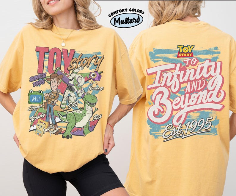 Pode incluir: Uma t-shirt amarelo mostarda com gr&aacute;ficos de Toy Story. A frente mostra Woody, Buzz Lightyear, Rex e outras personagens com o texto Toy Story Since 1995. As costas apresentam o log&oacute;tipo Toy Story e o texto To Infinity And Beyond Est. 1995.