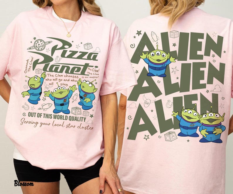 May include: Pink t-shirt featuring the Pizza Planet logo and three green aliens in blue suits. The front of the shirt has the text "Pizza Planet" and "Out of this world quality". The back of the shirt has the word "Alien" repeated.