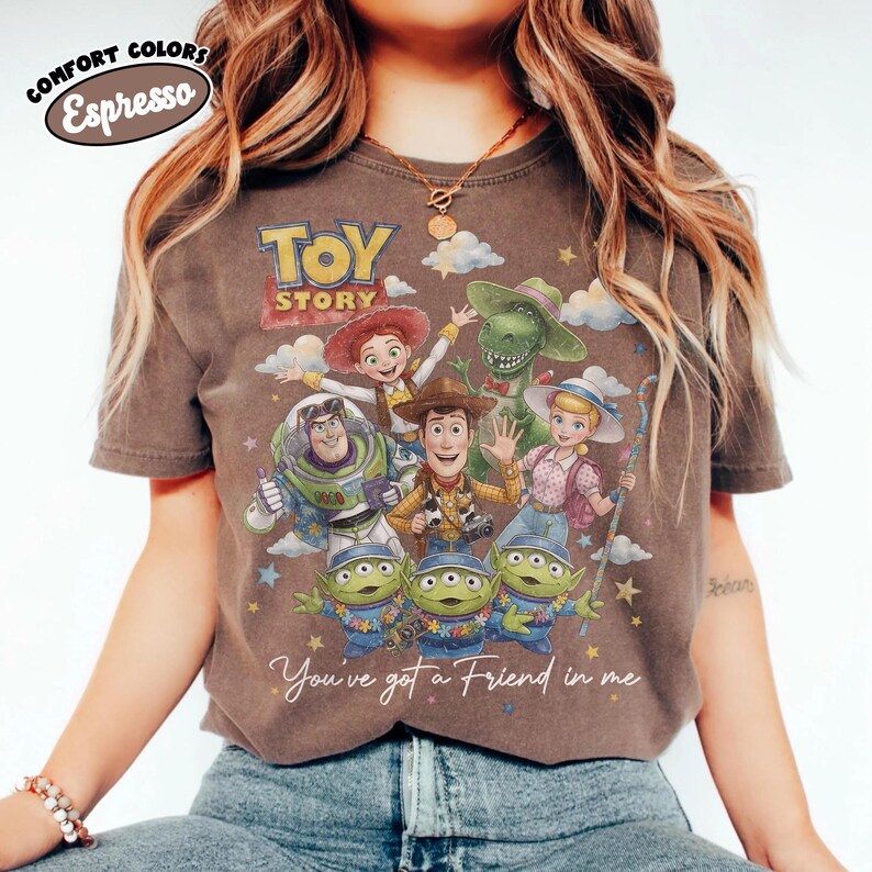May include: Espresso-coloured t-shirt with a Toy Story graphic featuring Woody, Buzz Lightyear, and the Little Green Men. The shirt displays the text "Toy Story" and "You've got a Friend in me."