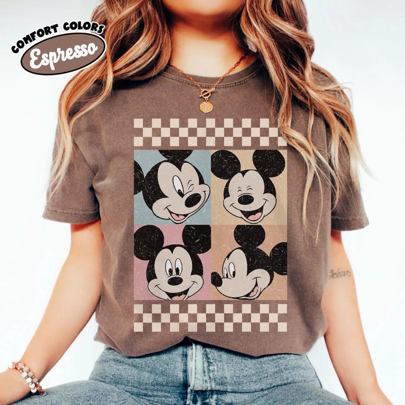 May include: Espresso-colored t-shirt featuring a retro design of Mickey Mouse's face in four squares. The shirt has a checkered border and the words "COMFORT COLORS" and "Espresso" in a circular design.