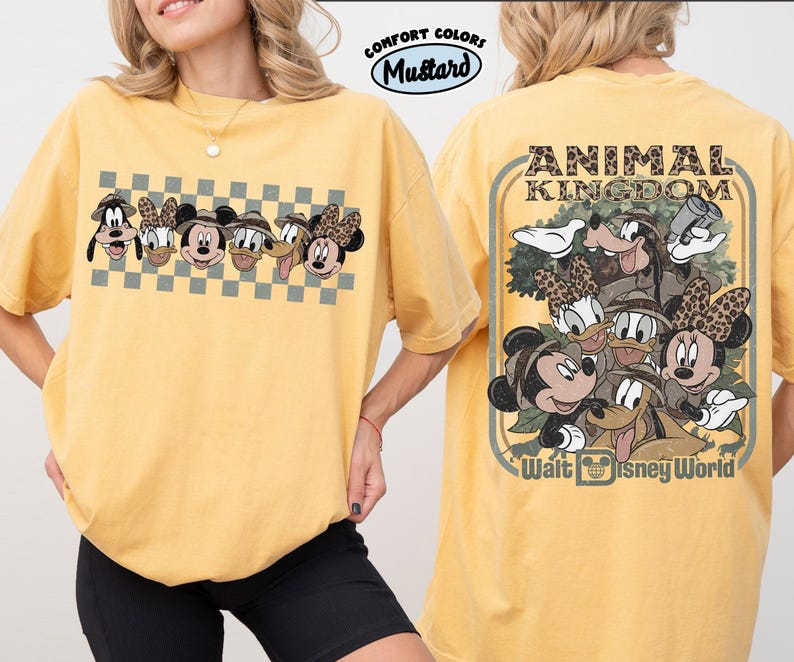 K&ouml;nnte beinhalten: Senfgelbes T-Shirt mit einer Grafik von Disney-Figuren, darunter Micky und Minnie Maus, Goofy und Donald und Daisy Duck. Auf der R&uuml;ckseite des Shirts steht "ANIMAL KINGDOM" und "Walt Disney World".