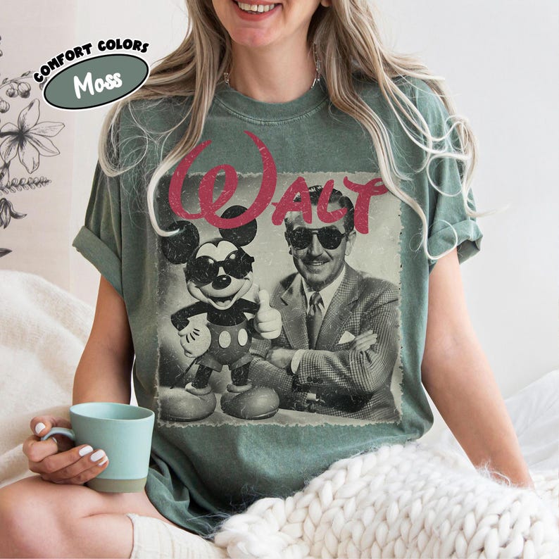 K&ouml;nnte beinhalten: Moosgr&uuml;nes T-Shirt mit einem Vintage-Grafik von Mickey Mouse und Walt Disney mit Sonnenbrille, mit dem Wort "WALT" in Rot. Das Shirt ist von der Marke Comfort Colors.