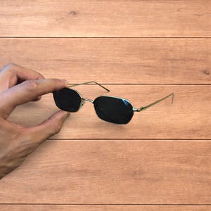 素敵なゴールドのメタルフレームとブラックのレンズが付いた偏光サングラス。