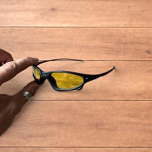 Gafas de sol polarizadas de color negro con lente amarilla.