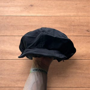 Vintage stijl krantenverkoper baret met platte pet in zwart.
