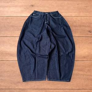 Könnte beinhalten: Dunkelblaue Jeans mit weitem, lockerem Schnitt. Die Jeans haben ein klassisches Fünf-Taschen-Design, einen Knopf- und Reißverschluss sowie weiße Nahtdetails. Die Hose liegt flach auf einer Holzoberfläche.