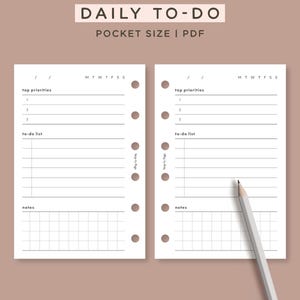 Könnte beinhalten: Ein digitaler Download einer täglichen To-Do-Liste im Taschenformat PDF. Das Design zeigt zwei weiße Seiten mit Abschnitten für oberste Prioritäten, eine To-Do-Liste und Notizen, mit einem Bleistift auf der rechten Seite. Der Text "DAILY TO-DO" steht oben.