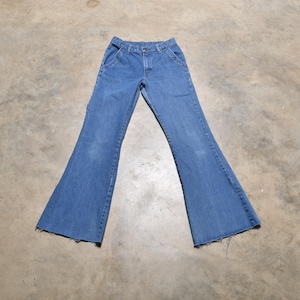 May include: A pair of blue denim bell bottom jeans with a frayed hem.