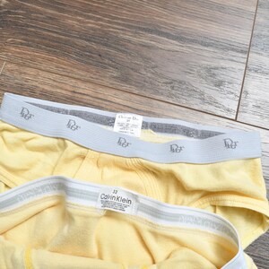 Pu&ograve; includere: Due paia di biancheria intima gialla con elastico in vita. Un paio presenta il logo "Christian Dior", e l'altro ha il logo "Calvin Klein". La biancheria intima &egrave; realizzata in un materiale morbido e confortevole.