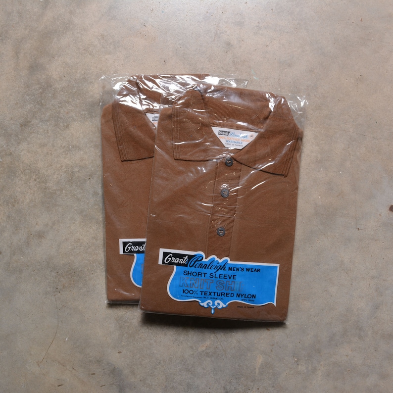 May include: Two brown short-sleeve knit shirts in plastic packaging. The label reads "Grant Glenleigh Men's Wear Short Sleeve Knit Shirt 100% Textured Nylon Made in Taiwan."