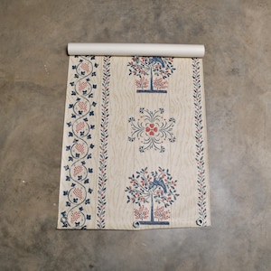Puede incluir: Un rollo de papel tapiz vintage con un patrón repetitivo de árboles, flores y enredaderas en tonos azules, rojos y blancos sobre un fondo crema.
