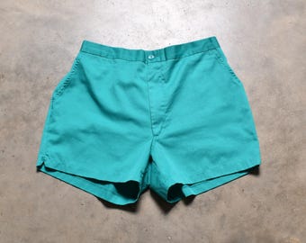 May include: Teal-colored shorts with a button closure and pockets. The shorts are made of a solid-colored fabric and have a classic, casual design. The shorts are a vibrant shade of teal, perfect for warm weather.