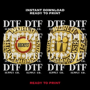 May include: Two gold-colored championship rings with the text "DTF SUPPLY CO." and "WORLD CHAMPIONS" on a black background. One ring features a basketball and the word "ROCKETS". The other ring has two trophies.