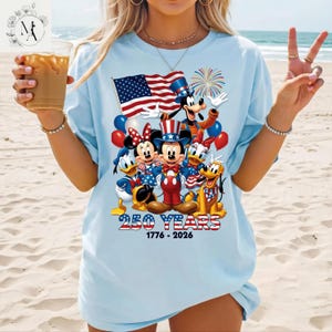 A woman wearing a t-shirt with a graphic design featuring Disney characters and the text "250 YEARS 1776 - 2026".