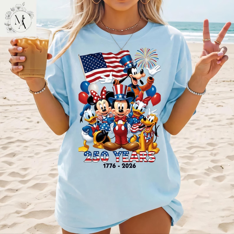 A woman wearing a t-shirt with a graphic design featuring Disney characters and the text "250 YEARS 1776 - 2026".
