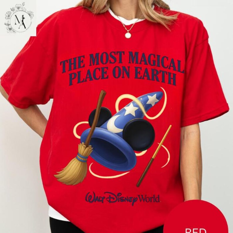 A red t-shirt with a graphic design featuring a wizard hat, broom, and wand, along with the text "The most magical place on earth" and "Disney World" printed on it.