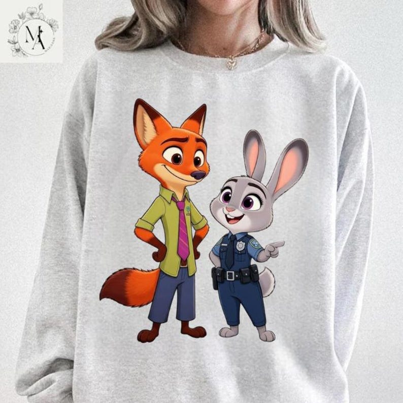 A person wearing a gray sweatshirt with an illustration of two cartoon police characters, a fox and a rabbit, standing together.