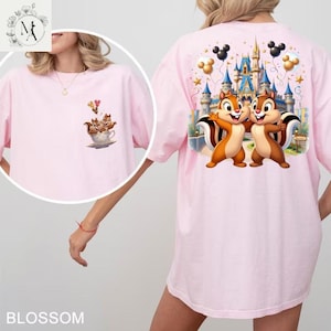 May include: Light pink t-shirt featuring a cartoon image of Chip and Dale in front of a castle on the back. The front of the shirt has a smaller image of the chipmunks in a teacup. The word "BLOSSOM" is at the bottom.