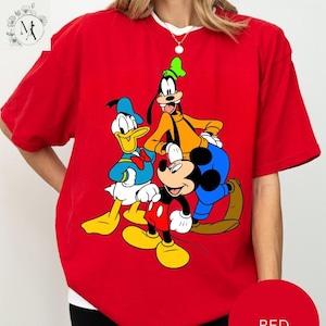 A red t-shirt with a graphic of Disney characters Mickey Mouse, Donald Duck, and Goofy.