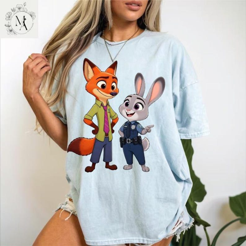 A woman wearing a light blue t-shirt with a cartoon image of a fox and a rabbit, which are characters from the animated film "Jumanji: The Next Level".