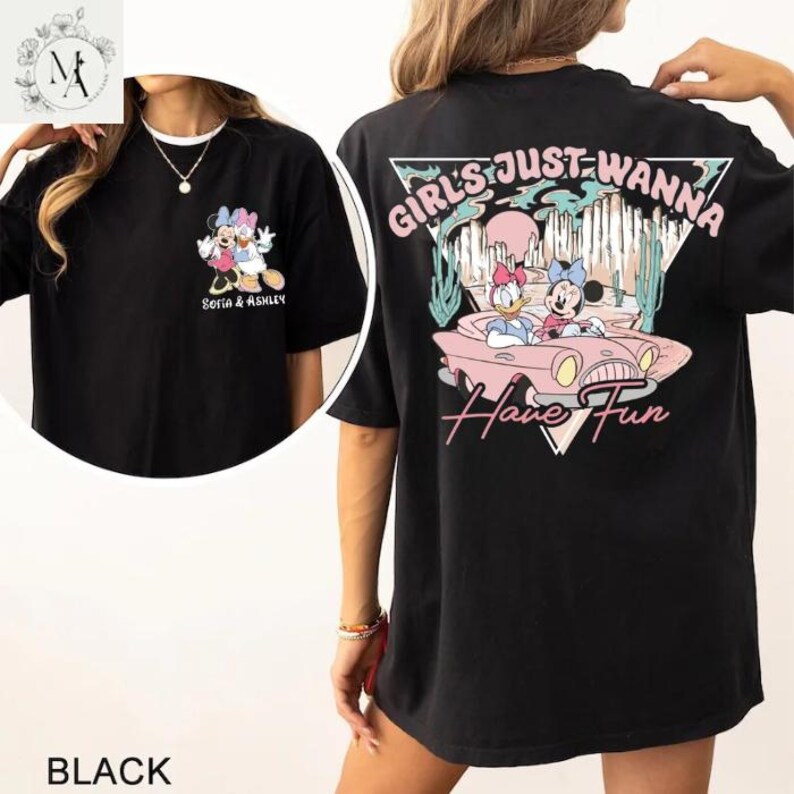 A black t-shirt with a graphic design featuring Minnie Mouse and Donald Duck riding in a car, along with the text "Girls Just Wanna Have Fun".
