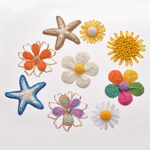 May include: A collection of handmade, colorful textile embellishments, including starfish and various flower designs. The flowers feature orange, white, yellow, and multi-colored petals with yellow centers. The starfish are beige and blue.