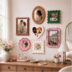 Puede incluir: Una composición decorativa de pared que incluye varios marcos, entre ellos un marco rectangular con cuentas, un espejo ovalado, un marco verde ondulado, un marco en forma de corazón, un marco con estampado floral, un espejo rosa ondulado y un marco cuadrado.