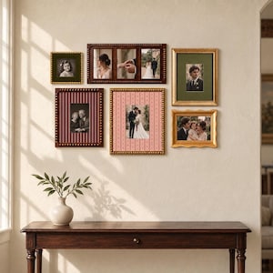 Puede incluir: Una composición de pared de galería con seis marcos de fotos variados. La colección incluye un marco cuadrado pequeño, un marco horizontal de tres paneles, dos marcos rectangulares verticales con paspartú estampado y dos marcos dorados con fotos.
