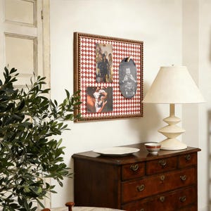May include: A framed photo display with a red and white diamond pattern background. The frame is brown with small, round, wooden beads. Three photos are displayed, including a black and white oval photo. A white lamp and a wooden dresser are also in the image.