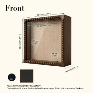 May include: A square dark brown wooden shadow box frame with a beaded border and a beige linen backing. The frame measures 11.14 inches by 11.14 inches externally, with a depth of 4.53 inches. It includes a rear hanging bracket for wall mounting.