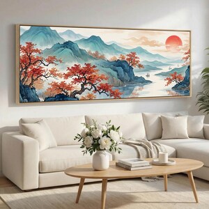 Könnte beinhalten: Ein panoramisches Landschaftsgemälde in einem Holzrahmen mit blauen Bergen, einem ruhigen Fluss mit kleinen Booten und leuchtend orange-roten Bäumen unter einer großen, hellroten Sonne. Das Kunstwerk zeigt eine ruhige Naturszene.